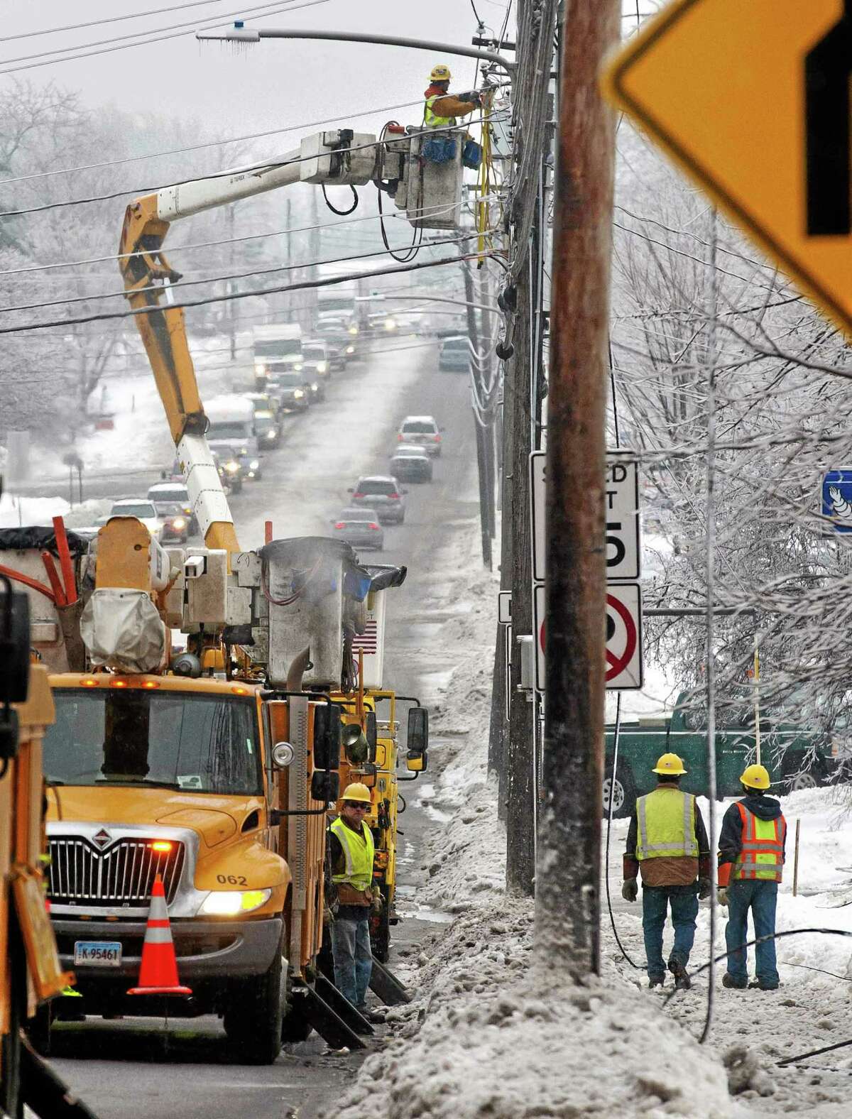 Utility crews respond to a downed power line at the intersection of Dorset Street and Kennedy Drive in South Burlington, Vt., on Monday, Dec. 23, 2013. From Michigan to Maine, hundreds of thousands remain without power days after a massive ice storm _ which one utility called the largest Christmas-week storm in its history _ blacked out homes and businesses in the Great Lakes and Northeast. (AP Photo/Burlington Free Press, Glenn Russell)
