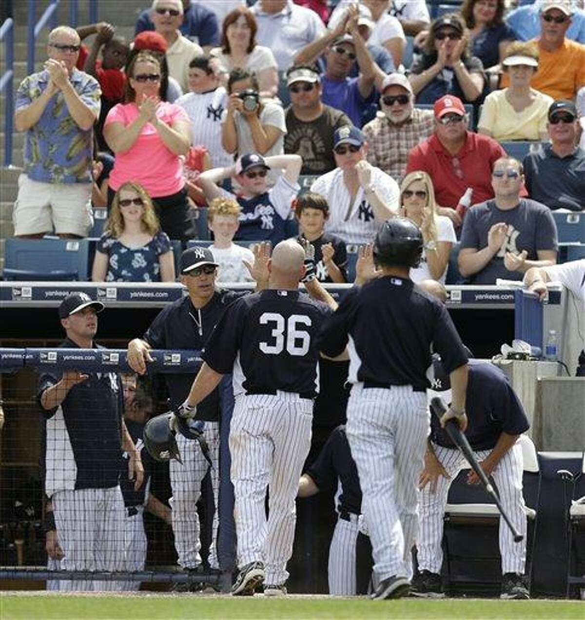 Fans and New York Yankees manager Joe Girardi greet and applaud Yankees Kevin Youkilis (36) after Youkilis hit a solo home run in a spring training baseball game in Tampa, Fla., Monday, March 11, 2013. (AP Photo/Kathy Willens)