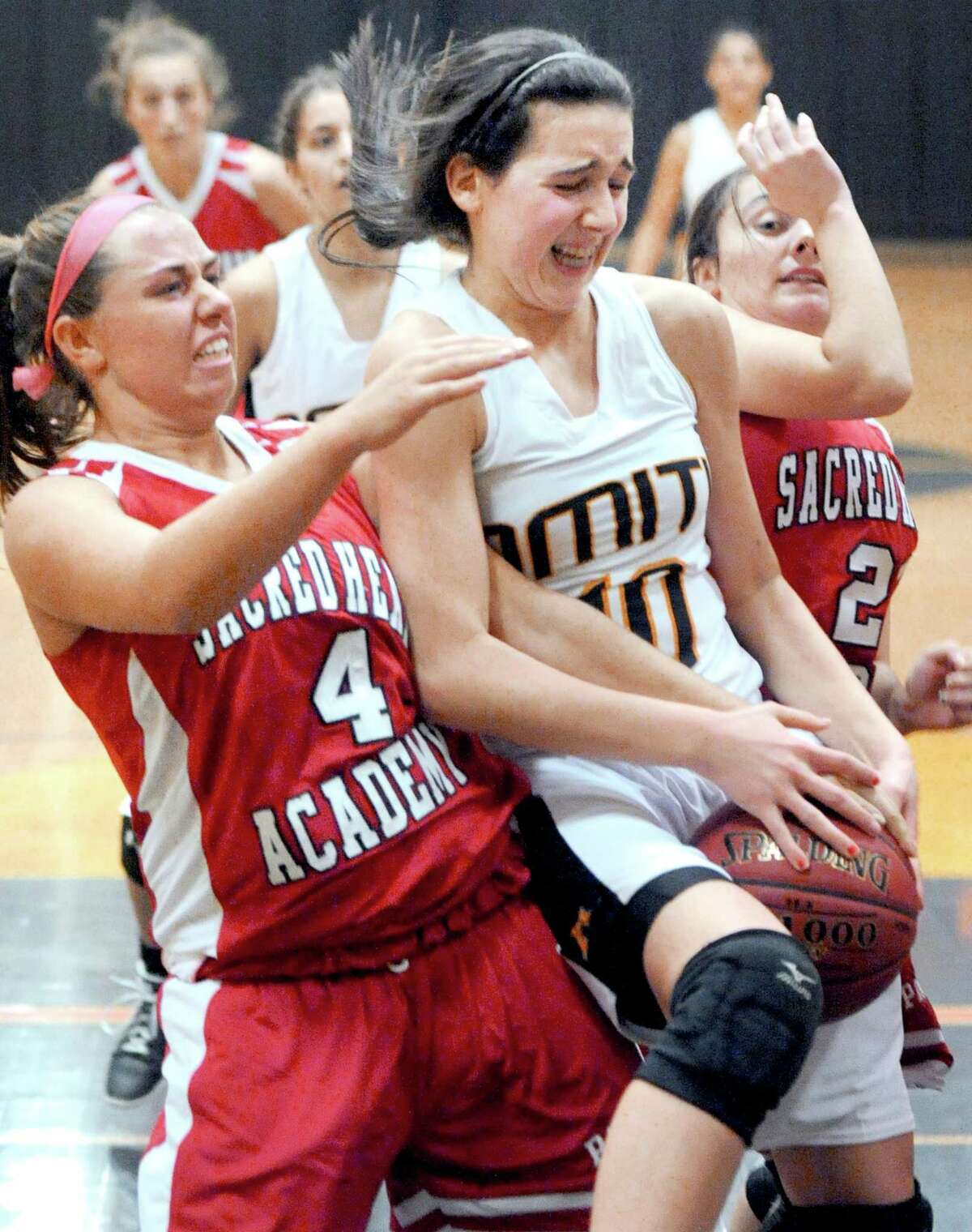 Lexi Caffaso (left) of Sacred Heart Academy reaches in trying to grab a rebound from Marie Papazian (right) of Amity in the second half of a game played earlier this season. SHA beat Cheshire on Wednesday. Photo by Arnold Gold/New Haven Register