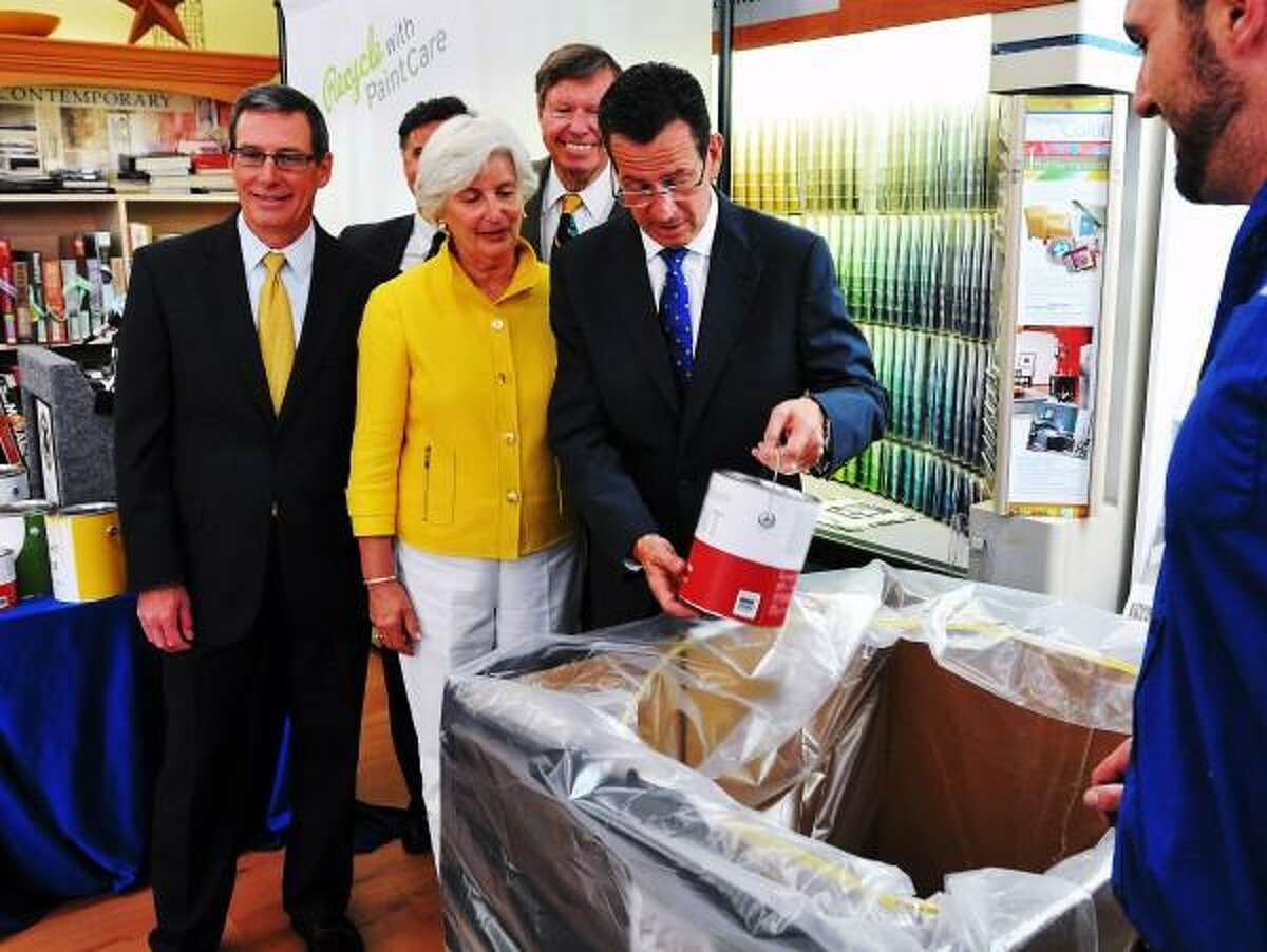 Gov. Dannel P. Malloy throws a symbolic can of unused paint away in a receptacle at the Branford Sherwin-Williams paint store. Malloy was in town with other government officials and the DEEP to announce a new program to recycle unused paints. Behind him, left to right is: Andy Dolye, president of the American Coatings Association; DEEP Commissioner Day Esty; Rep. Pat Widlitz and Sen. Ed Meyer. Peter Casolino/Register