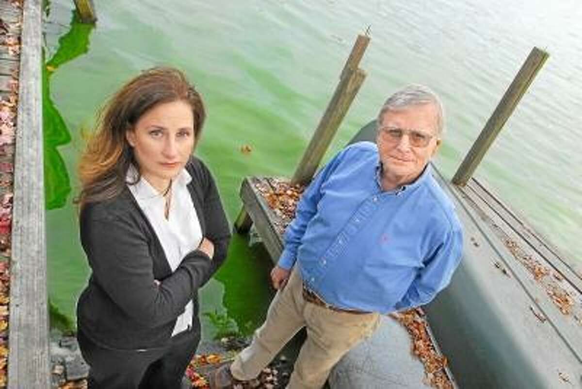 CATHERINE AVALONE/THE MIDDLETOWN PRESS Middlefield residents Amy Poturnicki, President of the Lake Beseck Association and Dick Boynton, Vice President of the LBA are seen on Boynton's dock agree the current condition of the algae in Lake Beseck may be the worse case lake residents may have seen. The association created an environmental committee to ultimately dredge the shallow areas of the lake to control the algae, curly leaf pond weed and milfoil to improve the water quality. DEEP has plans to rebuild the existing dam.