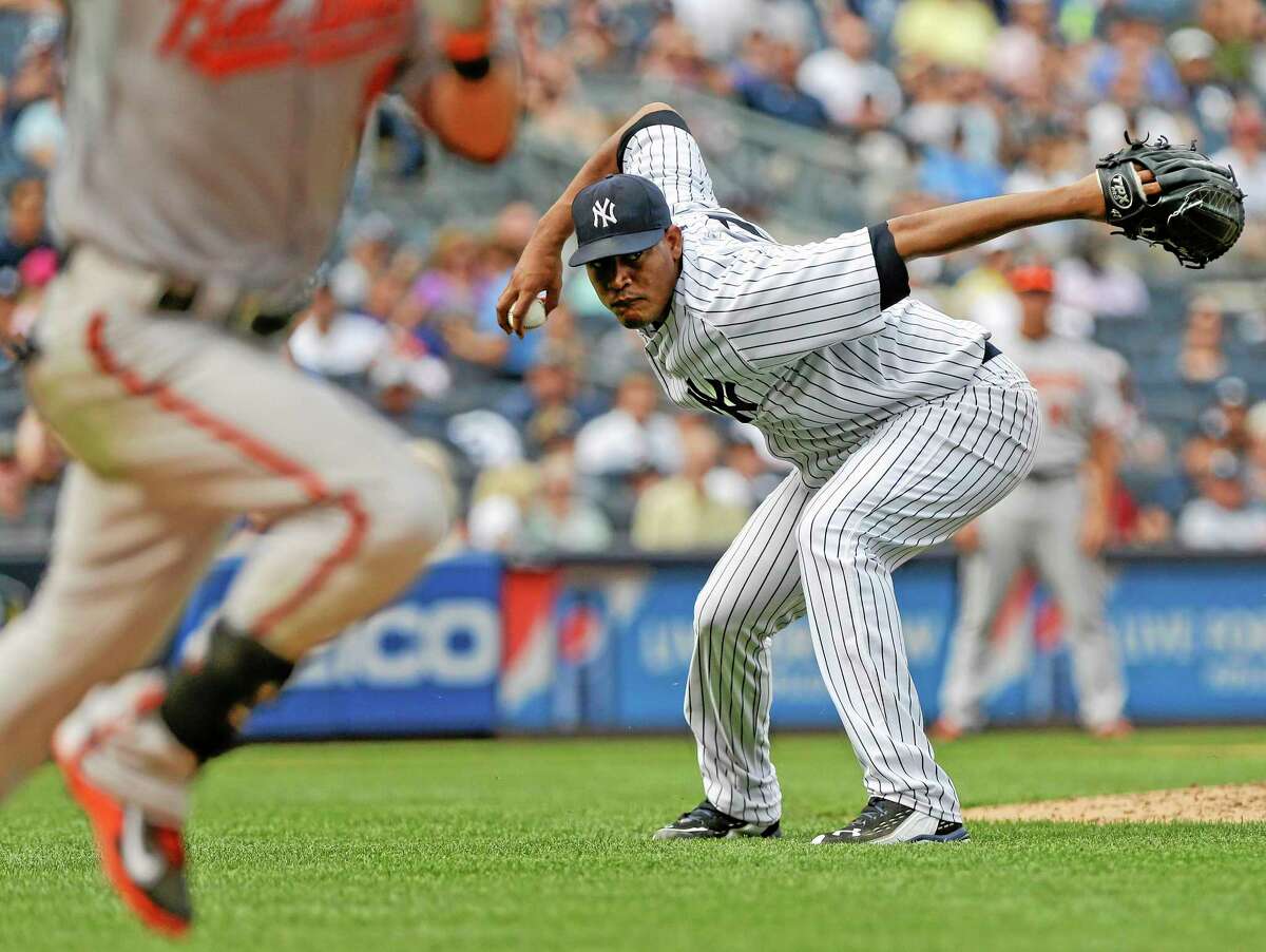 New York Yankees starting pitcher Ivan Nova attempts to throw out the Orioles’ Nate McLouth at first base during the ninth inning Saturday.