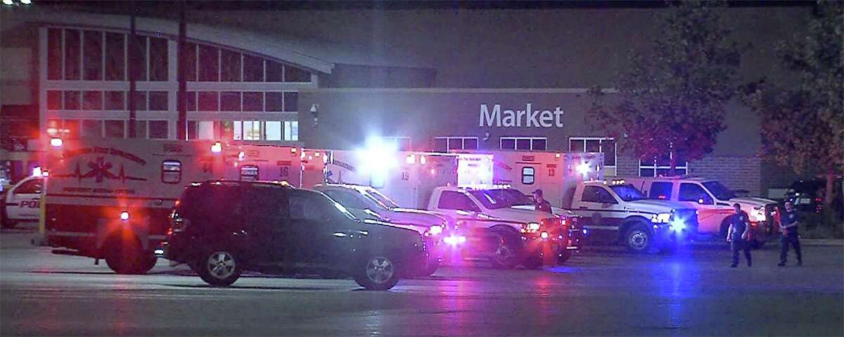 Emergency vehicles are seen in a parking lot at a Walmart located at IH-35 South and Palo Alto Road, Sunday, July 23, 2017. Law enforcement personnel found 38 immigrants inside a tractor-trailer parked at the store. Eight were found dead and two died later. Seventeen were transported with life-threatening injuries.