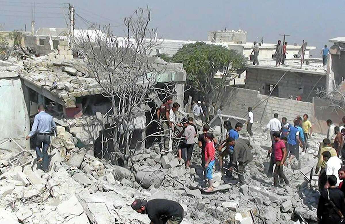 This citizen journalism image provided by Edlib News Network, ENN, which has been authenticated based on its contents and other AP reporting, Syrians search under rubble to rescue people from houses that were destroyed by a Syrian government warplane, in Idlib province, northern Syria, Friday, Aug. 30, 2013. United Nations experts are investigating the alleged use of chemical weapons in Syria as the United States and its allies prepare for the possibility of a punitive strike against President Bashar Assad's regime, blamed by the Syrian opposition for the attack. The international aid group Doctors Without Borders says at least 355 people were killed in the Aug. 21 attack in a suburb of Damascus, the Syrian capital.( AP Photo/Edlib News Network ENN)