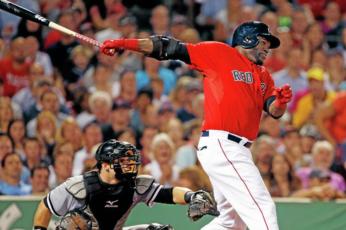 Red Sox designated hitter David Ortiz, right, hits a two-run single as Chicago White Sox catcher Josh Phegley watches in Friday’s game.