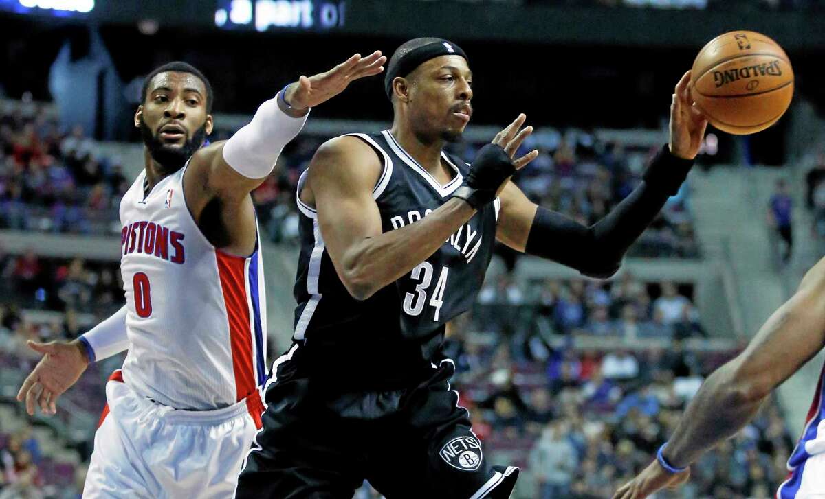 Brooklyn Nets forward Paul Pierce (34) passes the ball while being pressured by Detroit Pistons center and former UConn star Andre Drummond (0) during the first half Friday.