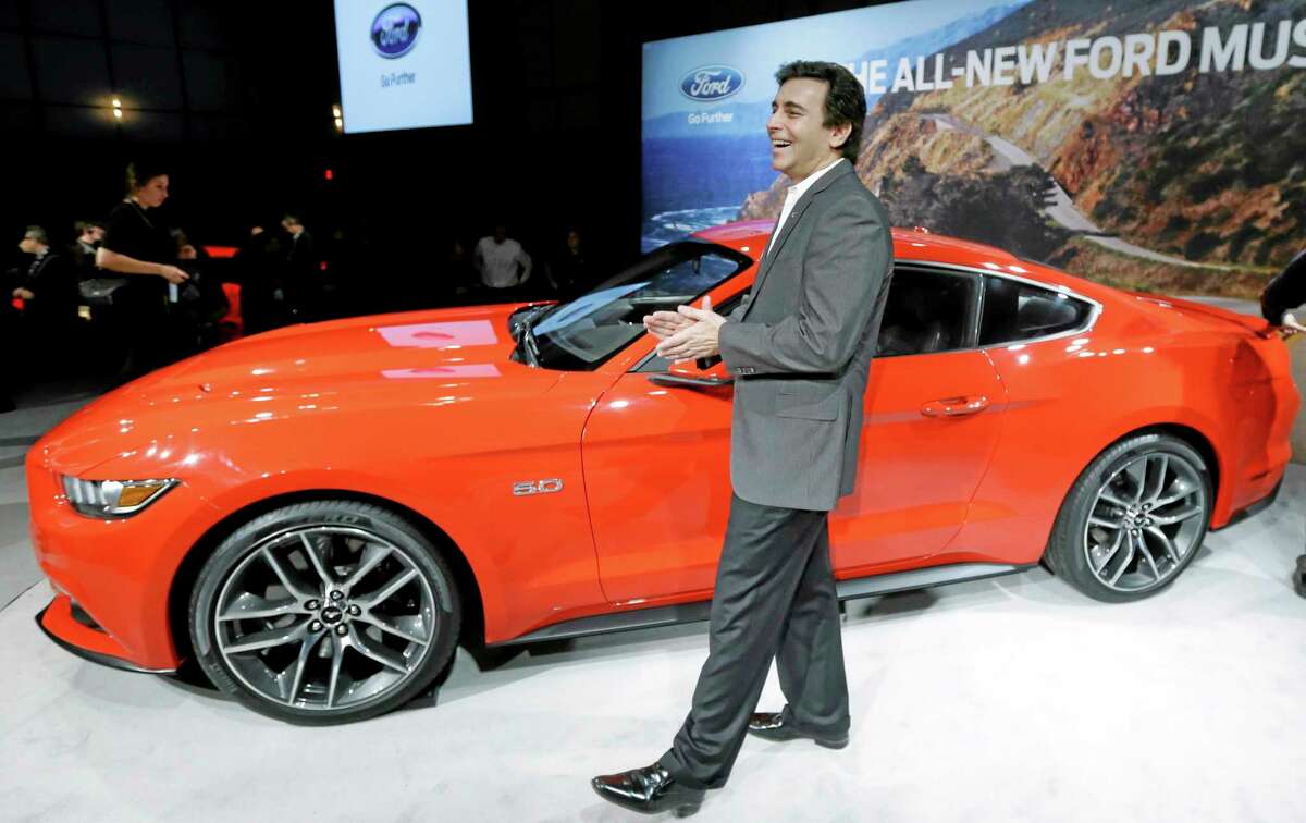 Mark Fields, left, chief operating officer for Ford Motor Company, stands next to the automaker's new 2015 Ford Mustang in Dearborn, Mich., Thursday, Dec. 5, 2013. The Mustang is celebrating its 50th birthday with a new design the automaker plans on taking global. It goes on sale next fall in North America and will arrive later in Europe and Asia. (AP Photo/Carlos Osorio)
