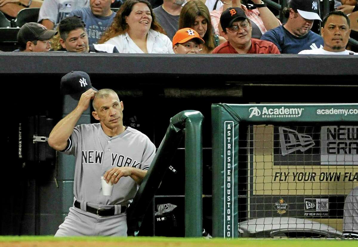 New York Yankees manager Joe Girardi scratches his head as he stands in the dugout in the 13th inning of Sunday’s game against the Astros in Houston. The Yankees won 5-1 in 14 innings.