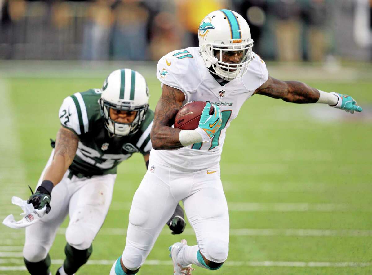 Miami Dolphins wide receiver Mike Wallace, right, breaks away from a tackle attempt from New York Jets cornerback Dee Milliner while catching a touchdown pass from quarterback Ryan Tannehill during Sunday’s game in East Rutherford, N.J.