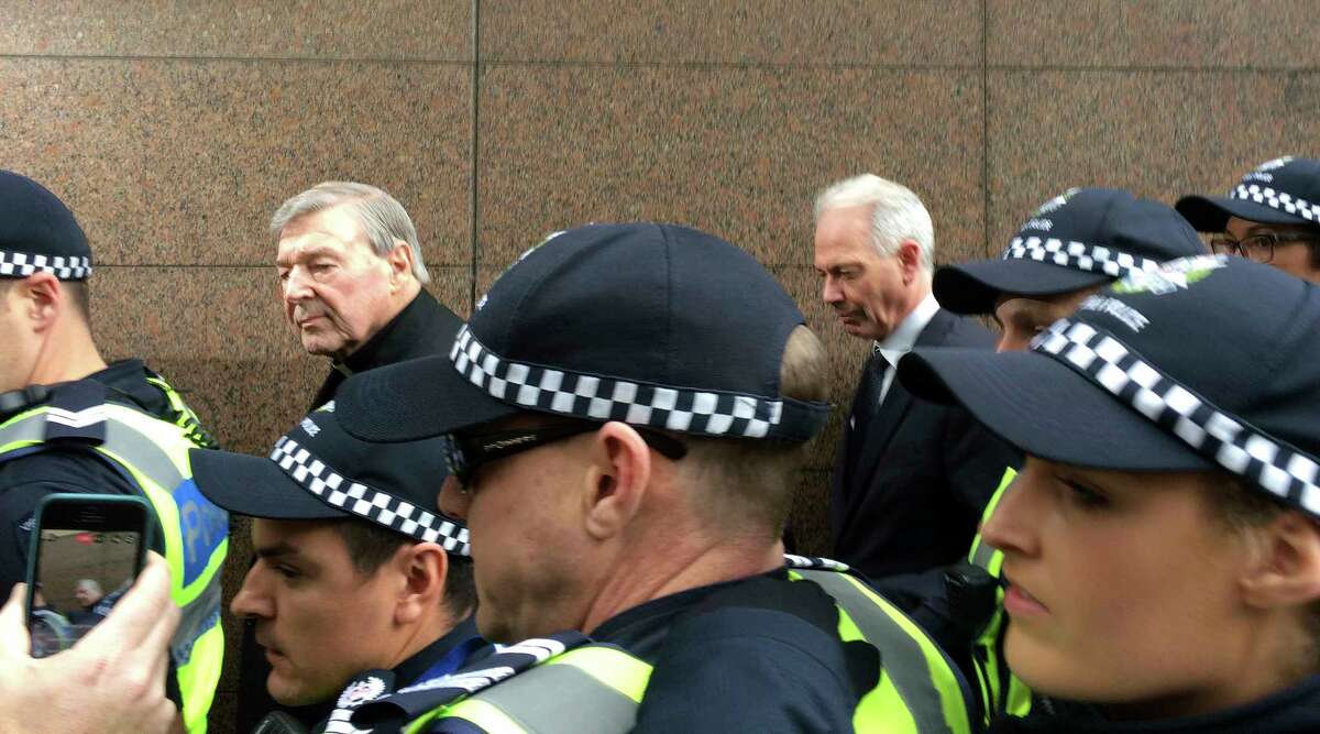 Cardinal George Pell, second left, Australia's highest-ranking Catholic and Pope Francis' top financial adviser, leaves Melbourne Magistrates' Court where he has maintained his innocence since he was charged last month with sexually abusing multiple people years ago, on Wednesday, July 26, 2017. The most senior Vatican official ever charged in the Catholic Church sex abuse crisis made his first court appearance in a scandal that has stunned the Holy See and threatened to tarnish the pope's image as a crusader against abusive clergy. (AP Photo/Kristen Gelineau)