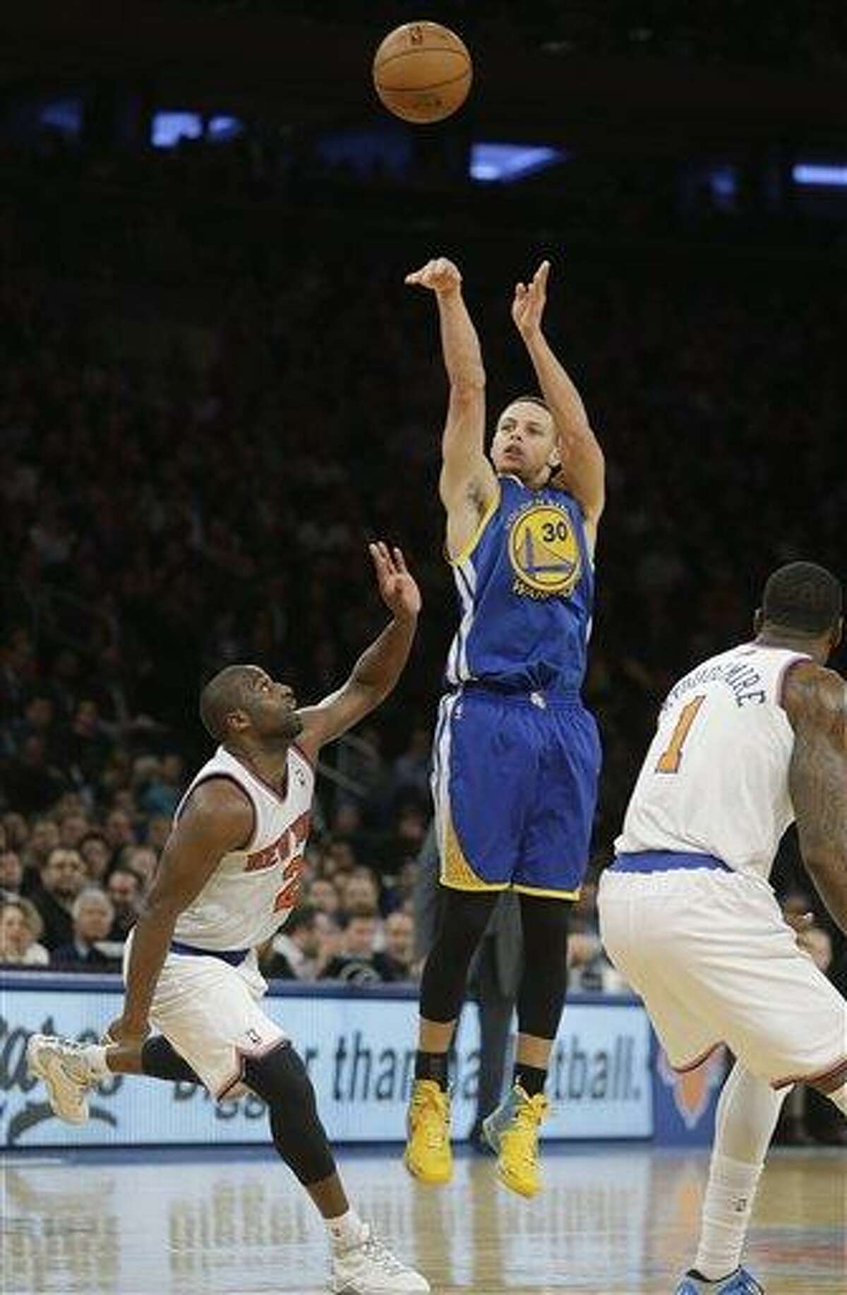 Golden State Warriors' Stephen Curry, center, shoots over New York Knicks' Raymond Felton, left, and Amare Stoudemire, right, during the second half of an NBA basketball game on Wednesday, Feb. 27, 2013, in New York. Curry scored 54 points. The Knicks won the game 109-105. (AP Photo/Frank Franklin II)