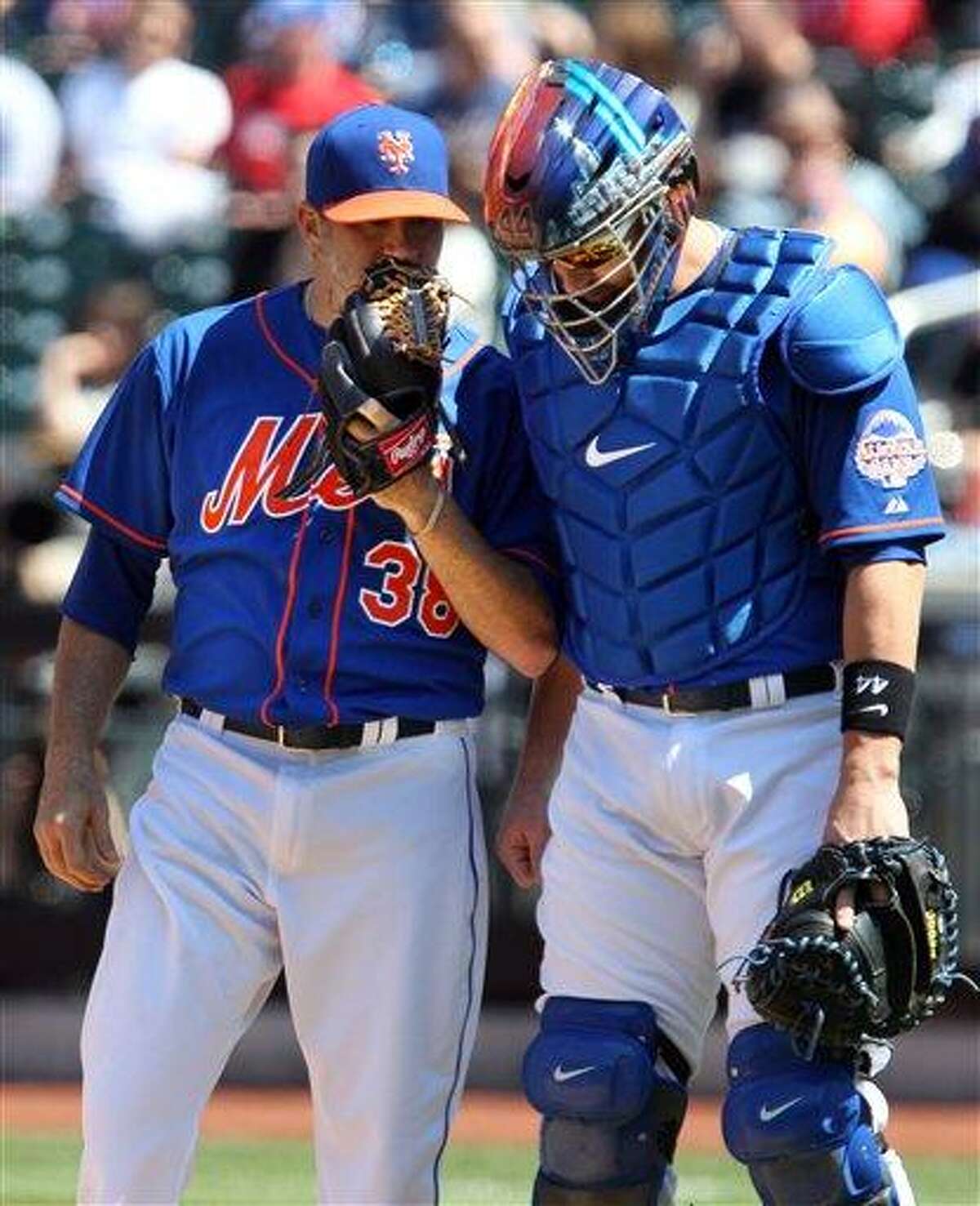New York Mets starting pitcher Shaun Marcum speaks with catcher John Buck in the third inning of a baseball game against the Philadelphia Phillies in New York on Saturday, April 27, 2013. (AP Photo/Peter Morgan)