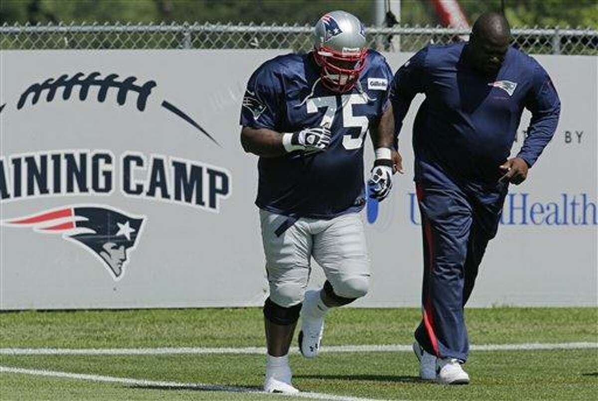 New England Patriots Vince Wilfork, left, runs with coach Pepper Johnson during a team NFL football practice in Foxborough, Mass., Tuesday, July 30, 2013.(AP Photo/Charles Krupa)