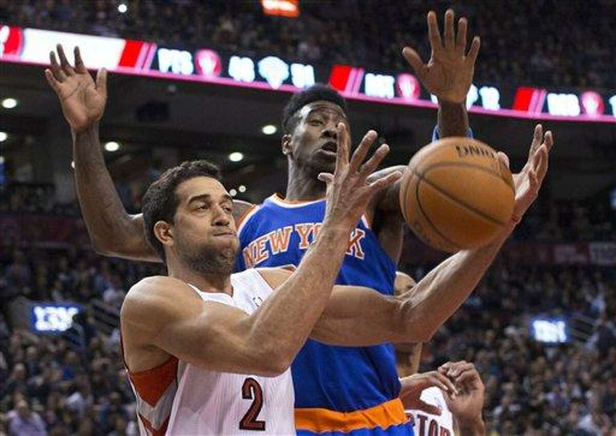Toronto Raptors' Landry Fields, left, and New York Knicks' Iman Shumpert try to get control of the ball during the first half of an NBA basketball game in Toronto on Friday, Feb. 22, 2013. (AP Photo/The Canadian Press, Chris Young)