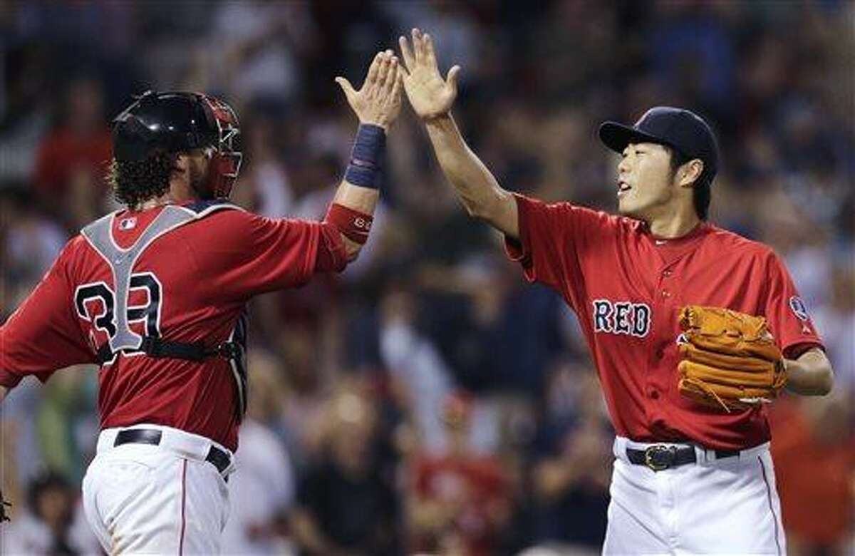 Boston Red Sox relief pitcher Koji Uehara, right, high-fives catcher Jarrod Saltalamacchia after final out of Boston's 7-5 win over the Toronto Blue Jays in a baseball game at Fenway Park, Friday, June 28, 2013, in Boston. Uehara earned a save in his outing. (AP Photo/Charles Krupa)