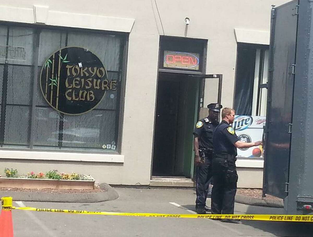 Officers outside the Tokyo Leisure Club in East Haven, which was raided Thursday afternoon. Jennifer Swift/Register