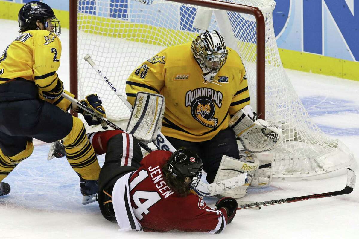Quinnipiac goalie Eric Hartzell (33) and defenseman Mike Dalhuisen (2) stop a third-period shot by St. Cloud State's Nick Jensen (14) during an NCAA college hockey Frozen Four game in Pittsburgh, Thursday, April 11, 2013. Quinnipaic advances to face Yale for the national championship title on Saturday. (AP Photo/Gene J. Puskar)