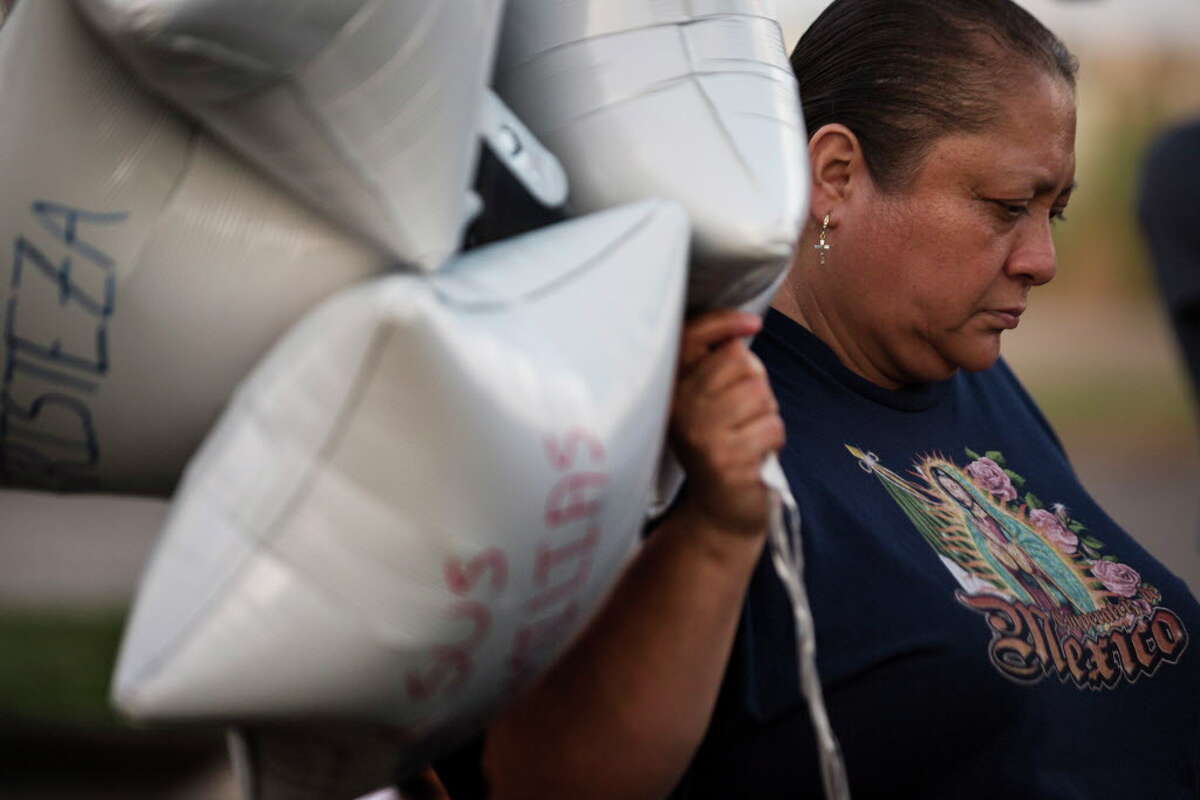 Maria Gonzalez holds balloons with words like fear and sadness written on them with the intention of releasing them to honor the 10 undocumented people who died in San Antonio Sunday morning trying to migrate to the United States. Tuesday, July 25, 2017, in Houston.