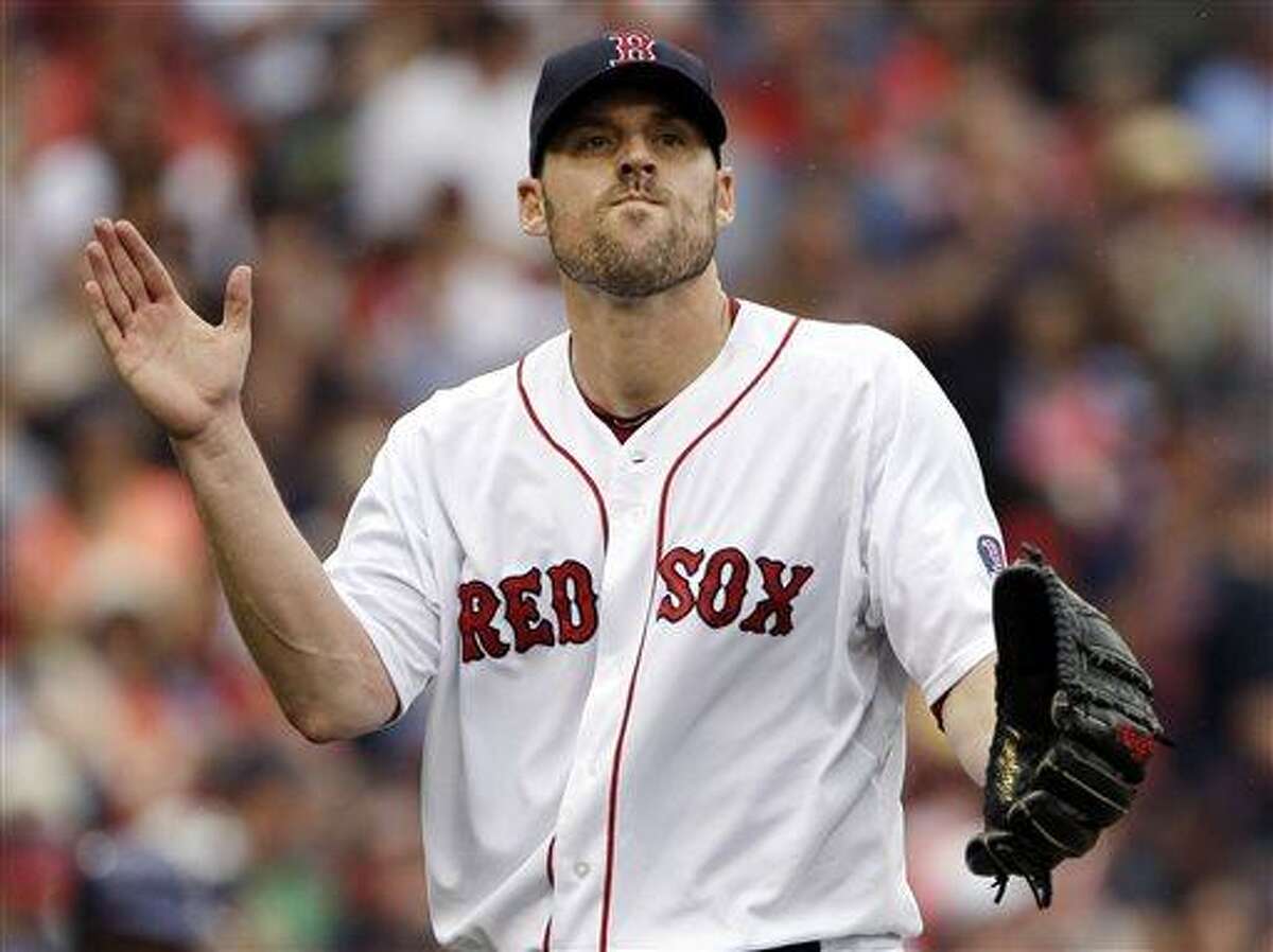 Boston Red Sox starting pitcher John Lackey claps after striking out Colorado Rockies' Tyler Colvin to end the top of the fourth inning of an interleague baseball game at Fenway Park in Boston, Wednesday, June 26, 2013. (AP Photo/Elise Amendola)