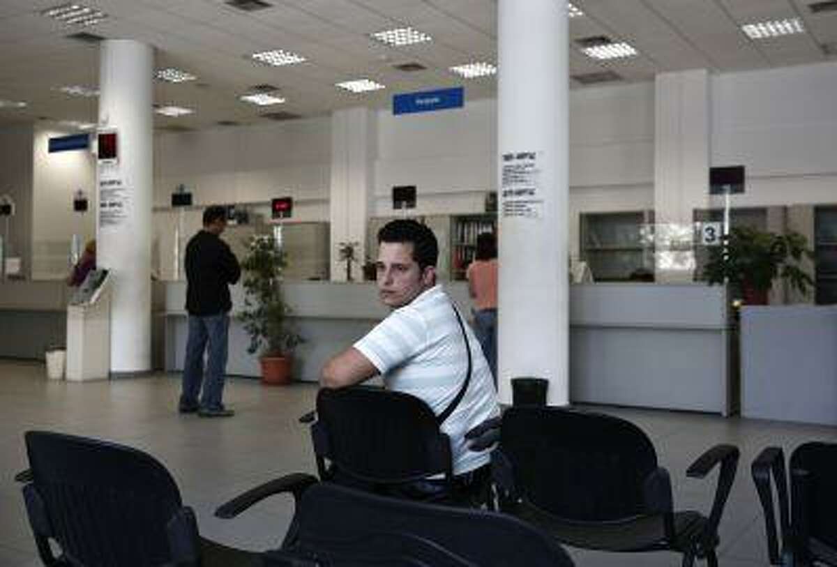 Greek Vangelis Xideas, 25, waits inside a Greek Manpower Employment Organisation office at a suburb of Athens June 14, 2013. Xideas has studied Accounting at the Technological Educational Institute of Mesolonghi and is looking for a job doing anything. (REUTERS/Yorgos Karahalis)