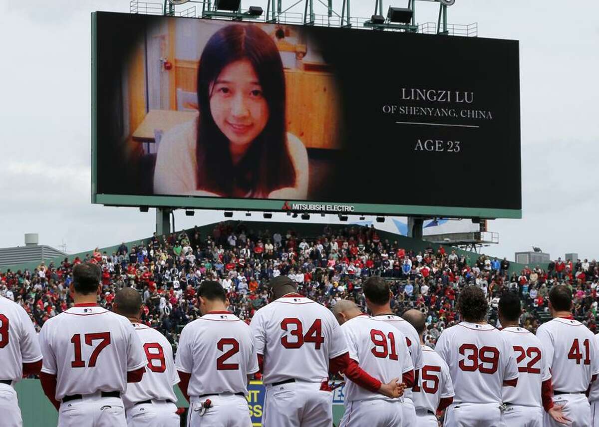 The Boston Red Sox stand during tribute to Boston Marathon bombing victims, including Chinese student Lingzi Lu, before a baseball game against the Kansas City Royals in Boston, Saturday, April 20, 2013. (AP Photo/Michael Dwyer)