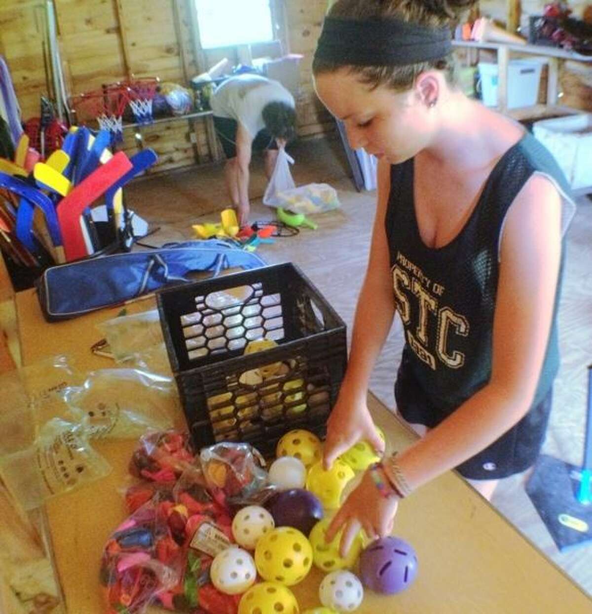 JOHN HAEGER @ONEIDAPHOTO ON TWITTER/ONEIDA DAILY DISPATCH Kelli Vachon works to inventory sports equipment at Madison County Childrens Camp Camp Lookout on Monday, June 24, 2013.