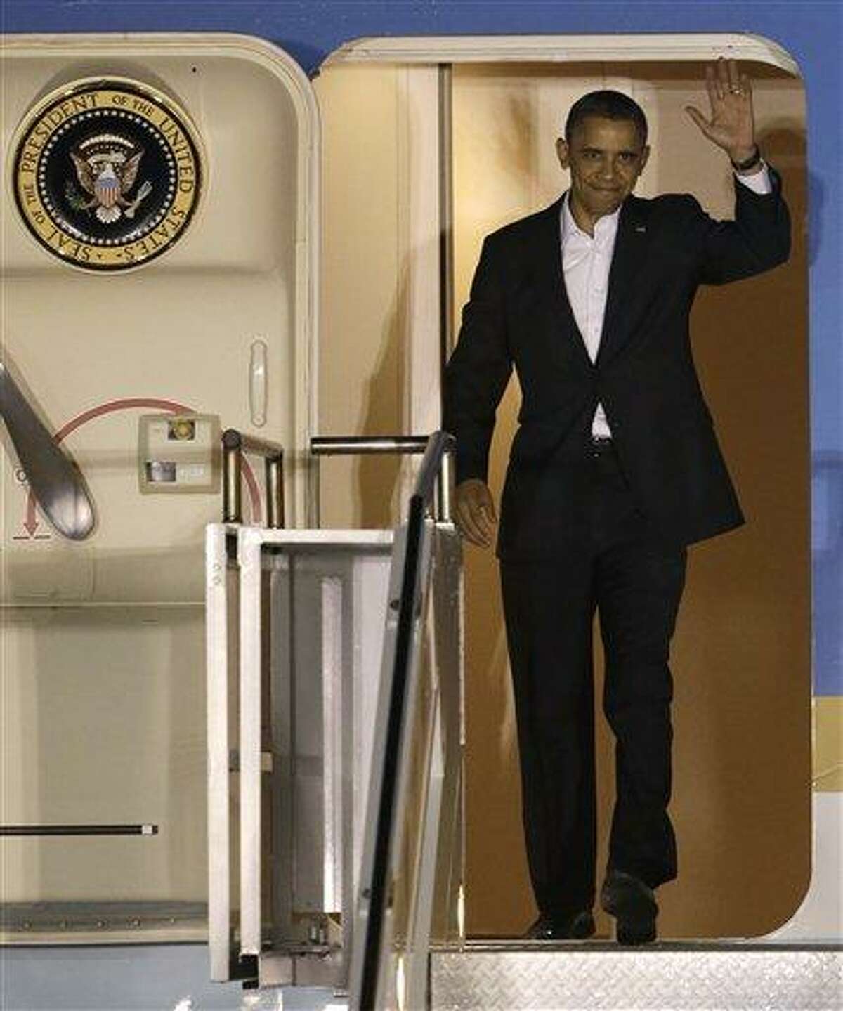 President Barack Obama waves as he walks down the stairs of Air Force One upon his arrival at Palm Beach International Airport. AP Photo/Wilfredo Lee