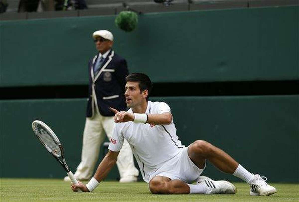Novak Djokovic of Serbia gestures after slipping against Florian Mayer of Germany in their Men's first round singles match at the All England Lawn Tennis Championships in Wimbledon, London, Tuesday, June 25, 2013. (AP Photo/Sang Tan)