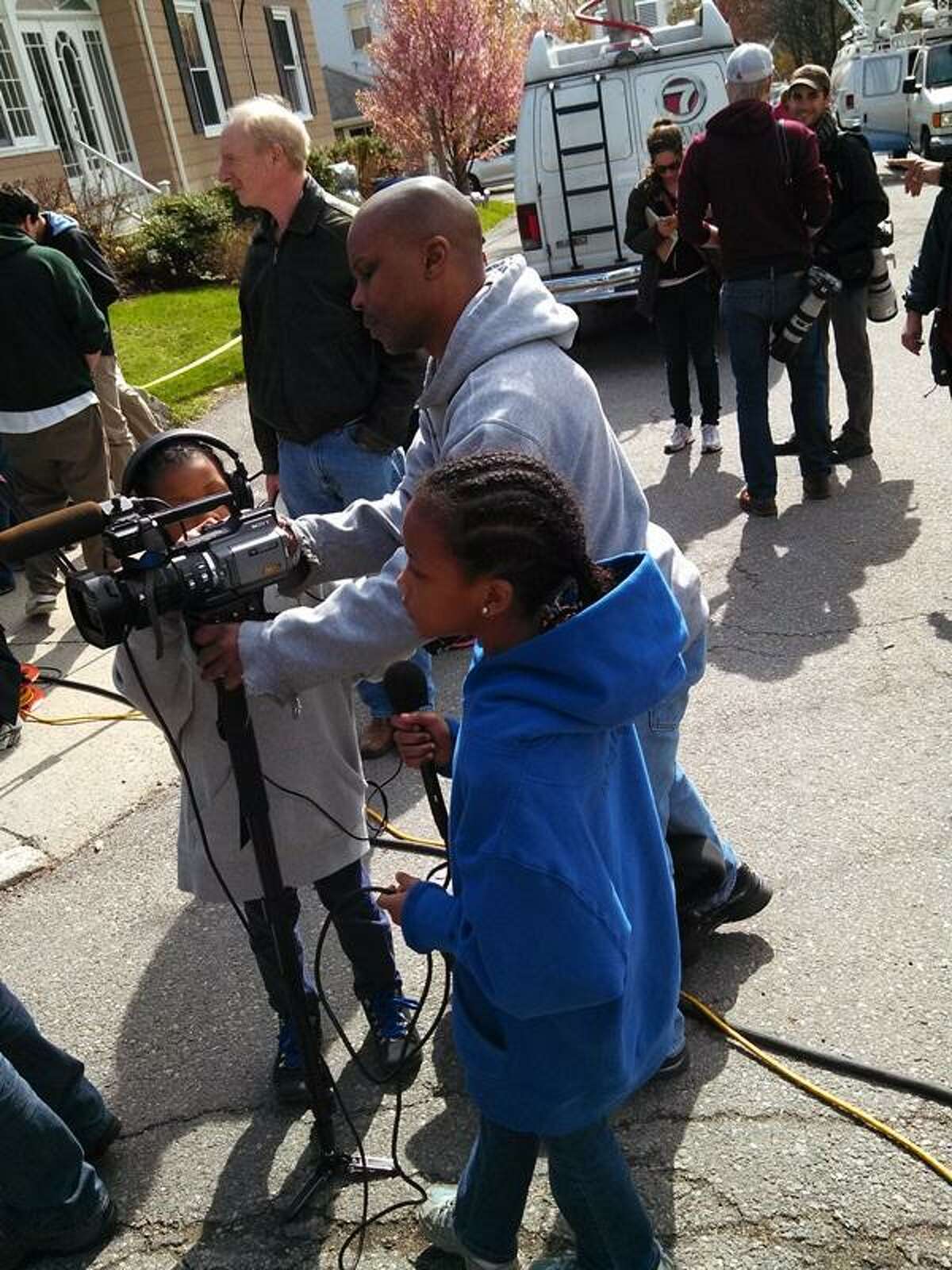 On Saturday, Robert Broadway of Roxbury, Mass. brought his daughters Helena, 9, and Haniyah, 10 to the scene where a Boston Marathon suspect was captured less than 24 hours before. He said by letting the girls ask questions and take pictures they can learn more about what happened. Photo by Jenn Smith