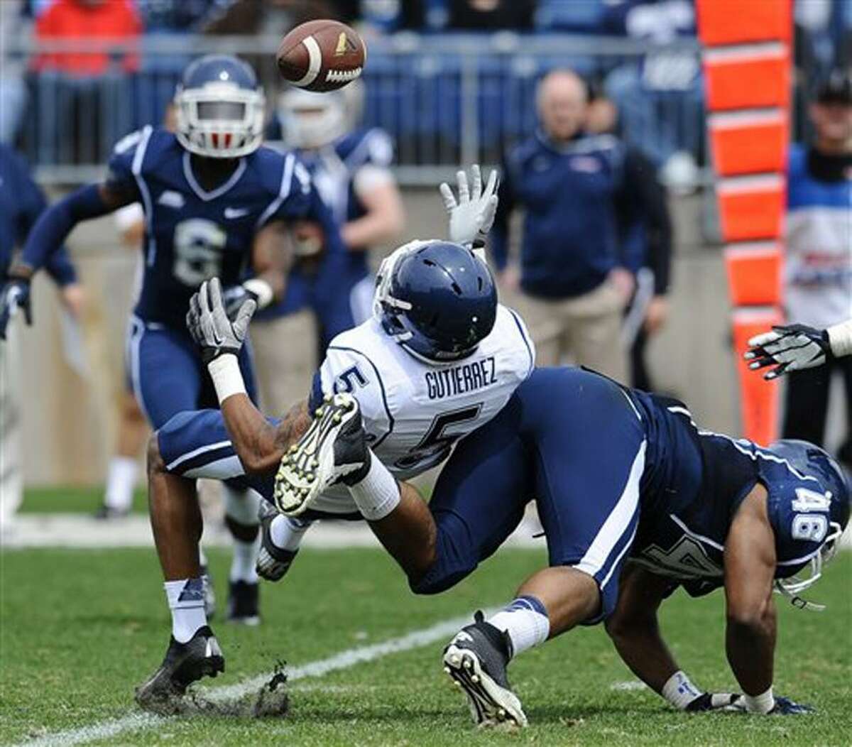 Connecticut's Ricky Gutierrez, left, is upended by Marquise Vann during the UConn's Blue-White spring NCAA college football game at Rentschler Field in East Hartford, Conn., Saturday, April 20, 2013. (AP Photo/Jessica Hill)