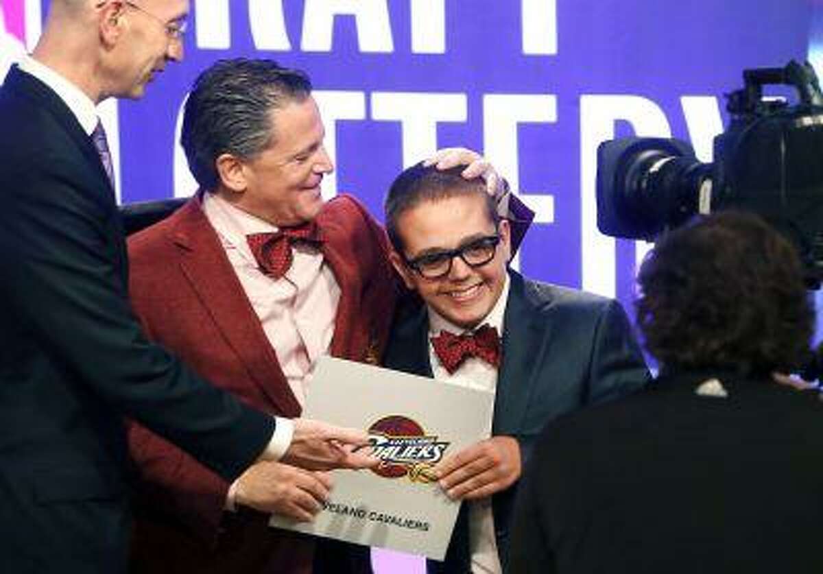 Cleveland Cavaliers owner Dan Gilbert congratulates his son Nick Gilbert after the team won the NBA basketball draft lottery, Tuesday, May 21, 2013 in New York.