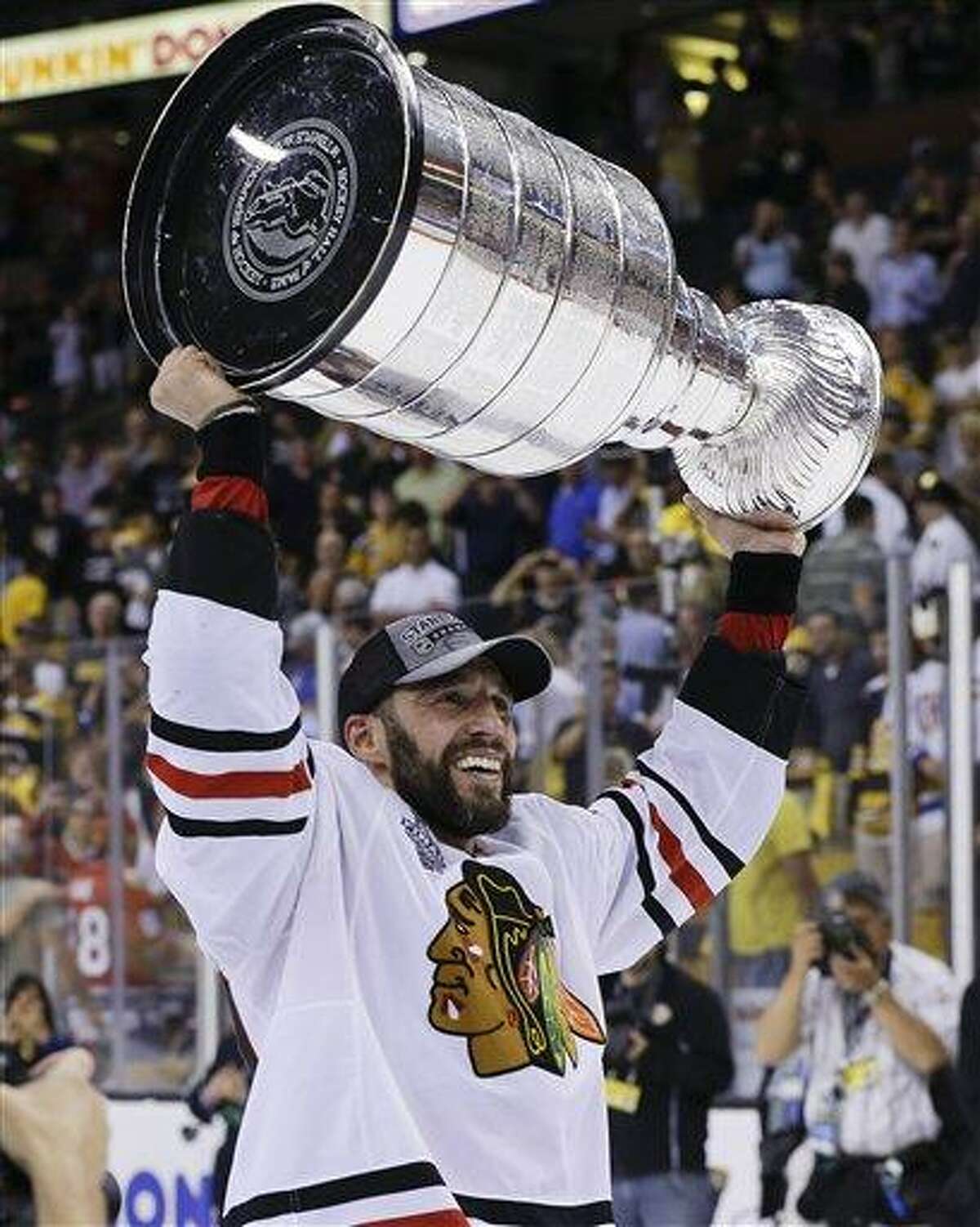 Chicago Blackhawks defenseman Michal Rozsival, of the Czech Republic, hoists the Stanley Cup after the Blackhawks beat the Boston Bruins 3-2 in Game 6 of the NHL hockey Stanley Cup Finals Monday, June 24, 2013, in Boston. (AP Photo/Elise Amendola)