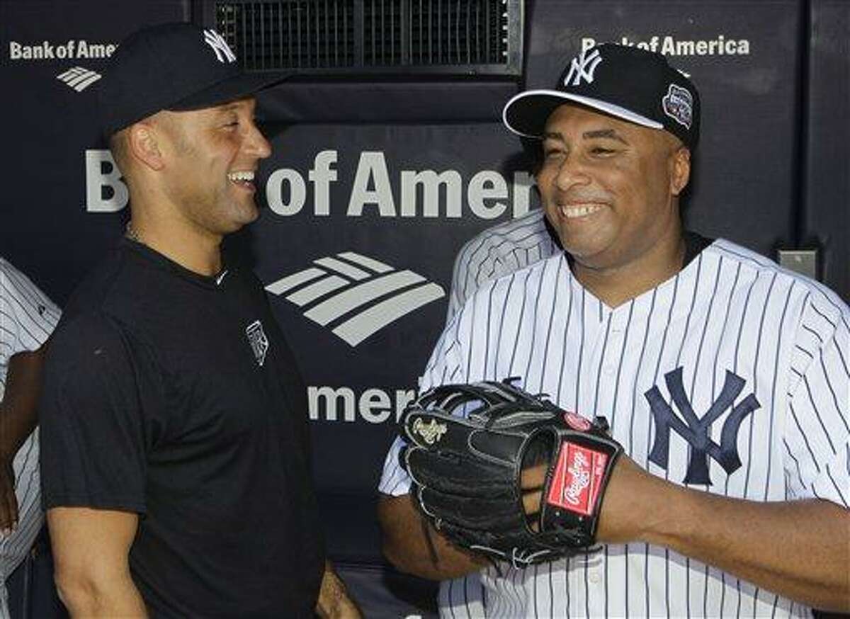New York Yankees shortstop Derek Jeter, left, who is on the disabled list, shares a laugh with former New York Yankees outfielder Bernie Williams in the dugout before the Old Timers Day baseball game Sunday, June 23, 2013, in New York. (AP Photo/Kathy Willens)