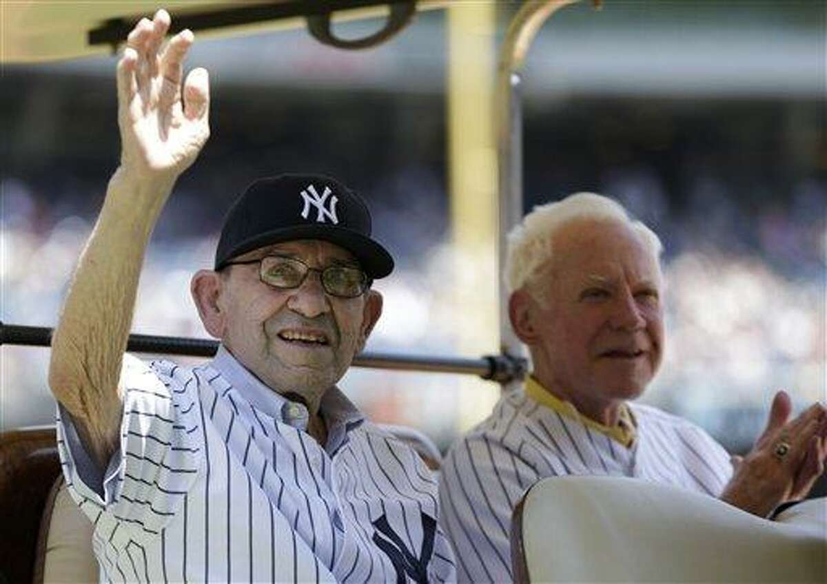 New York Yankees Hall-of-Famer Yogi Berra, left, waves as fellow Hall-of-Famer Whitey Ford applauds during introductions before the Yankees Old Timers Day baseball game on Sunday, June 23, 2013, at Yankee Stadium in New York. (AP Photo/Kathy Willens)