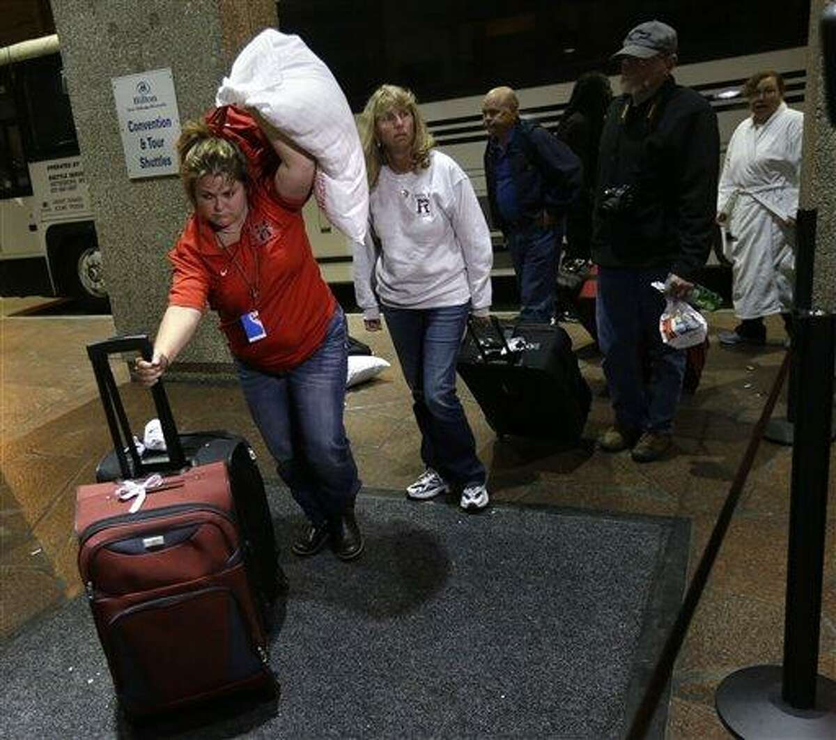 Passengers from the disabled Carnival Triumph cruise ship arrive by bus at the Hilton Riverside Hotel in New Orleans, Friday, Feb. 15, 2013. The ship had been idled for nearly a week in the Gulf of Mexico following an engine room fire. (AP Photo/Gerald Herbert)
