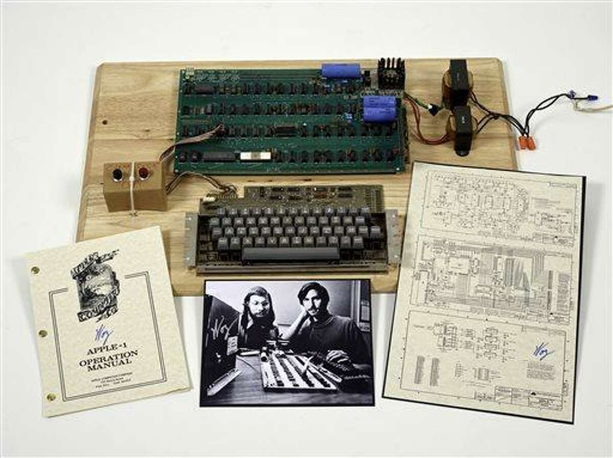 This undated photo provided by Christie's Auction House shows an "Apple 1" prototype computer, built in 1976, accompanied by an operation manual and schematic as well as a photo of its inventors, Steve Wozniak, left, and Steve Jobs. One of the very first Apple 1 computers, it goes on sale later this month at Christie's auction house, the latest in a recent run of vintage tech sales that have attracted some eye-popping prices. (AP Photo/Christies Images Ltd. 2013)