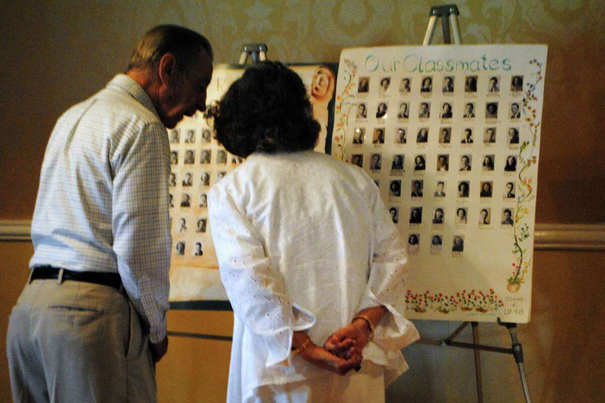 Attendees of the 1948 class reunion look at high school pictures of deceased classmates. Jessica Glenza - Register Citizen