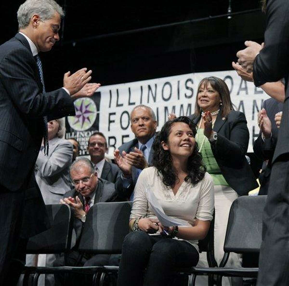 Chicago Mayor Rahm Emanuel, left, joins other officials in giving Arianna Salgado a standing ovation for the speech she gave before Illinois Gov. Pat Quinn signed the Illinois Dream Act into law, Monday, Aug. 1, 2011, at a Latino neighborhood high school in Chicago. The new Illinois law gives illegal immigrants access to private scholarships for college. Students qualify if they attended an Illinois high school for at least three years, received a diploma and have at least one parent who is an immigrant. Immigrant children here both illegally and legally can apply. Salgado, who worked with activists to help pass the bill, is a recent high school graduate who came to the U.S. from Mexico when she was 6-years-old, and she is not a U.S. citizen. She will enter Dominican University in the fall. (AP Photo/M. Spencer Green)