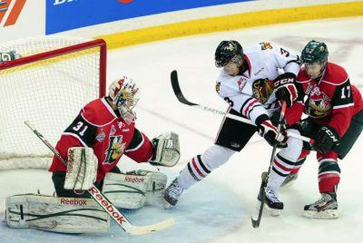 In this May 26, 2013, file photo, Portland Winterhawks defenseman Seth Jones, center, goes to the net in front of Halifax Mooseheads right winger Darcy Ashley, right, as Mooseheads goaltender Zachary Fucale defens during the first period of the Memorial Cup final hockey game in Saskatoon, Saskatchewan. Jones, the son of former NBA basketball player Ronald "Popeye" Jones, is likely to be No. 1 pick in the NHL draft, which will be held in Newark, N.J., on June 30.