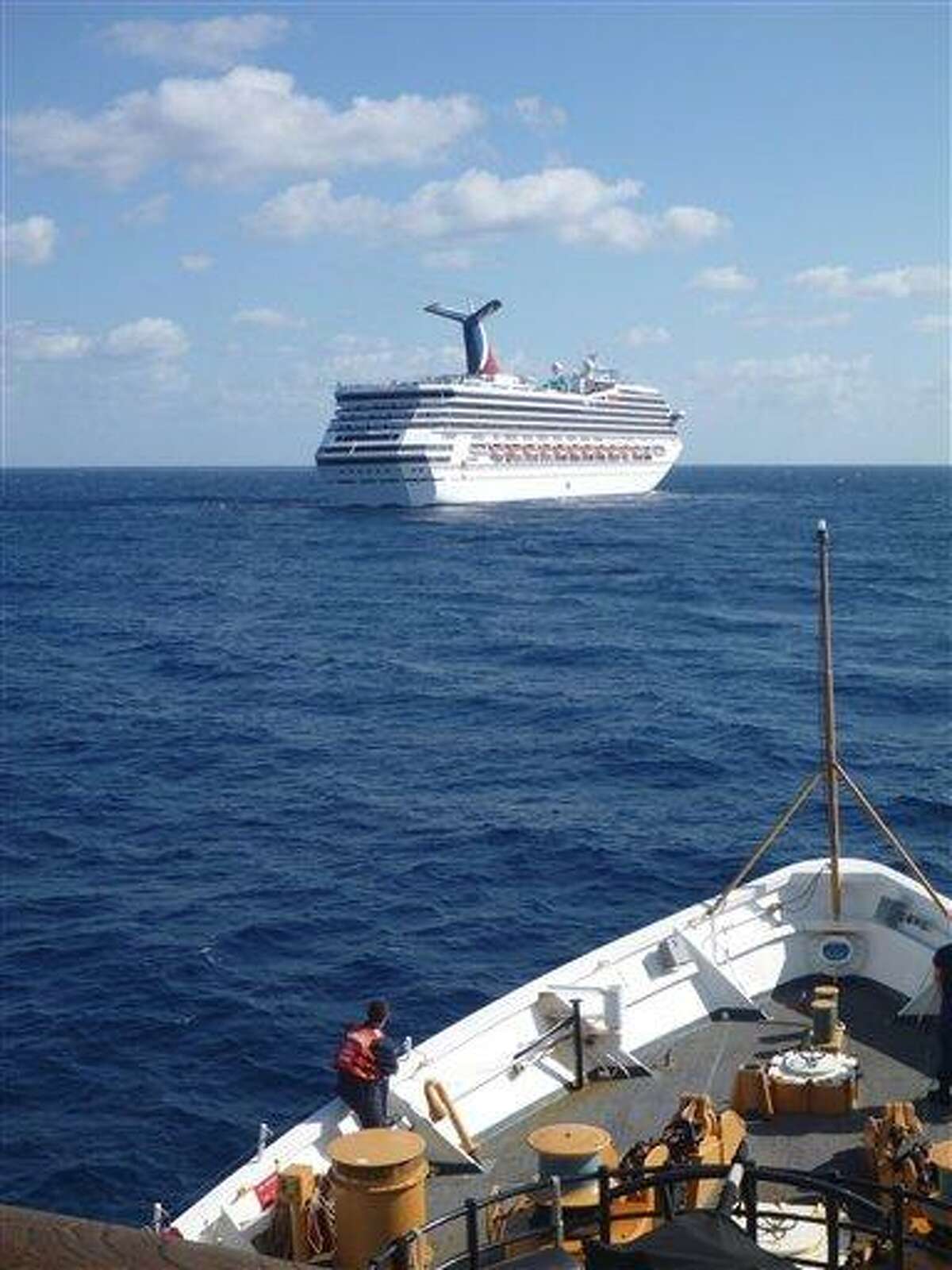 In this image released by the U.S. Coast Guard on Feb. 11, 2013, the Coast Guard Cutter Vigorous patrols near the cruise ship Carnival Triumph in the Gulf of Mexico, Feb. 11, 2013. The Carnival Triumph has been floating aimlessly about 150 miles off the Yucatan Peninsula since a fire erupted in the aft engine room early Sunday, knocking out the ship's propulsion system. No one was injured and the fire was extinguished. AP Photo/U.S. Coast Guard- Lt. Cmdr. Paul McConnell