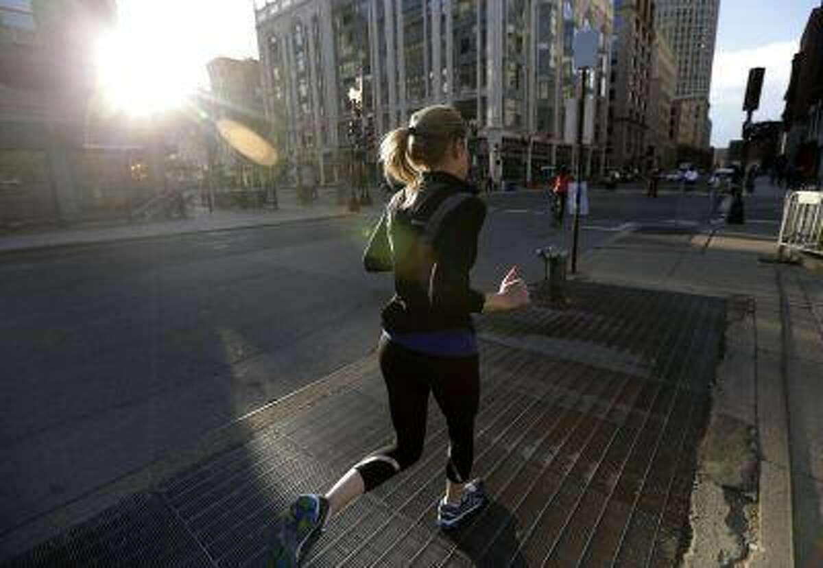 A jogger trots near the corner of Berkeley Street and Boylston Street not far from the finish line of the Boston Marathon, Wednesday, April 17, 2013, in Boston. The city continues to cope following Monday's explosions near the finish line of the marathon. (AP Photo/Julio Cortez)