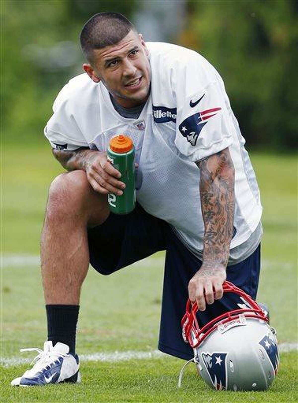 FILE - In this May 29, 2013, file photo, New England Patriots' Aaron Hernandez kneels on the field during NFL football practice in Foxborough, Mass. Hernandez is being sued in South Florida by a man claiming Hernandez shot him in the face after an argument at a strip club. The lawsuit comes as police in New England investigate Hernandez's possible connection to the death of a semipro player. (AP Photo/Michael Dwyer, File)