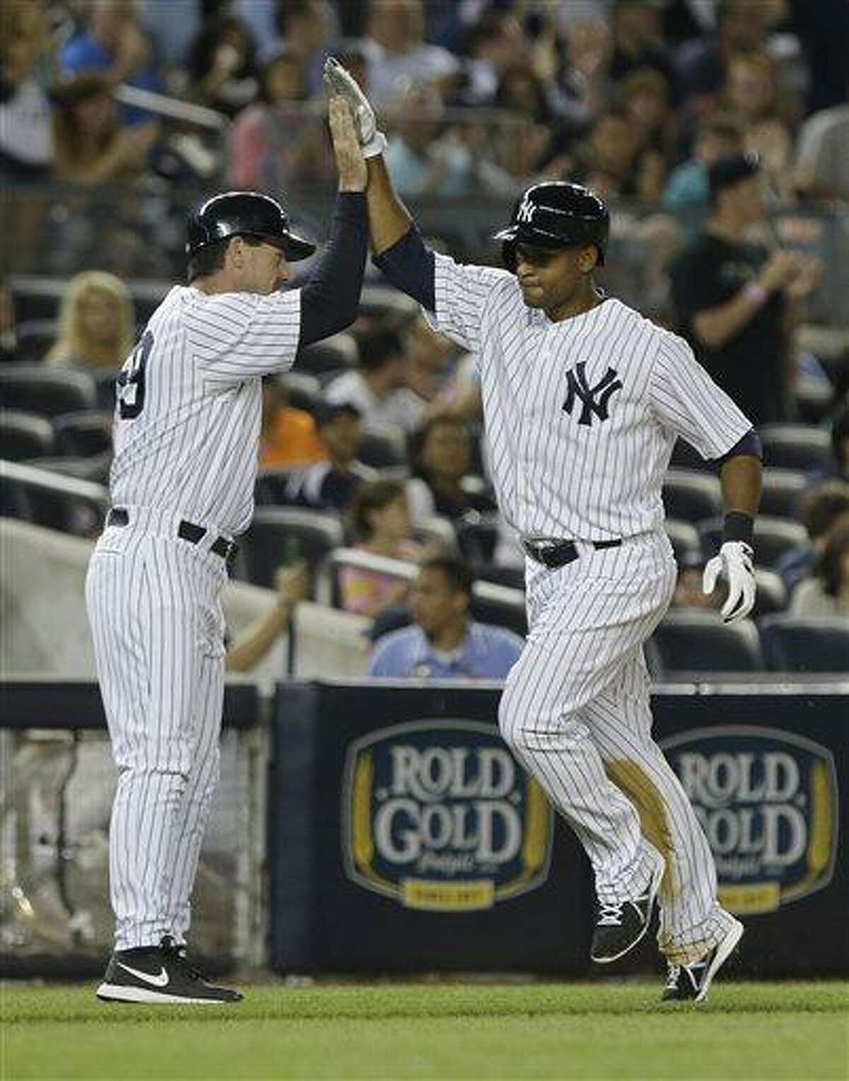 New York Yankees' Zoilo Almonte, right, celebrates with third base coach Rob Thomson as he heads to home plate after hitting a home run during the sixth inning of a baseball game on Friday, June 21, 2013, in New York. (AP Photo/Frank Franklin II)