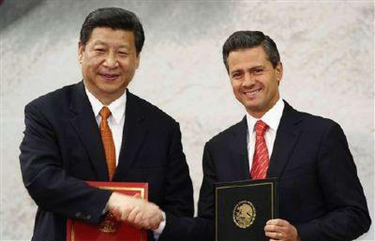 In this Tuesday, June 4, 2013 file photo, Chinese President Xi Jinping, left, and his Mexican counterpart Enrique Pena Nieto pose for photographers during an agreement signing ceremony at Los Pinos presidential residence in Mexico City.(Marco Ugarte/AP)