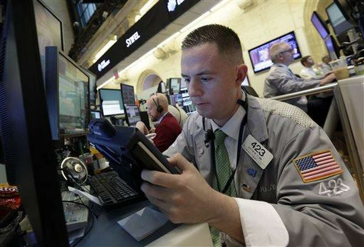 Trader Justin Flinn works in a booth on the floor of the New York Stock Exchange, Thursday, June 20, 2013. Financial markets are sliding after the Federal Reserve said it could end its huge bond-buying program by the middle of next year. (AP Photo/Richard Drew)
