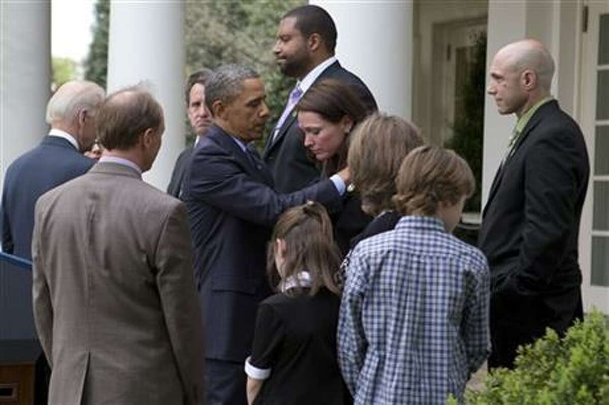 President Barack Obama hugs Nicole Hockley, whose son Dylan was killed in the shooting at Newtown, while surrounded by other Newtown families after speaking about the Rose Garden about the failure of gun legislation to pass in Congress, in the Rose Garden at the White House in Washington, Wednesday, April 17, 2013. Watching in the foreground are Mark and Jackie Barden and their children Natalie and James, along with Jeremy Richman, right, Jimmy Greene, back center, and Neil Heslin, back left facing camera. (AP Photo/Jacquelyn Martin)