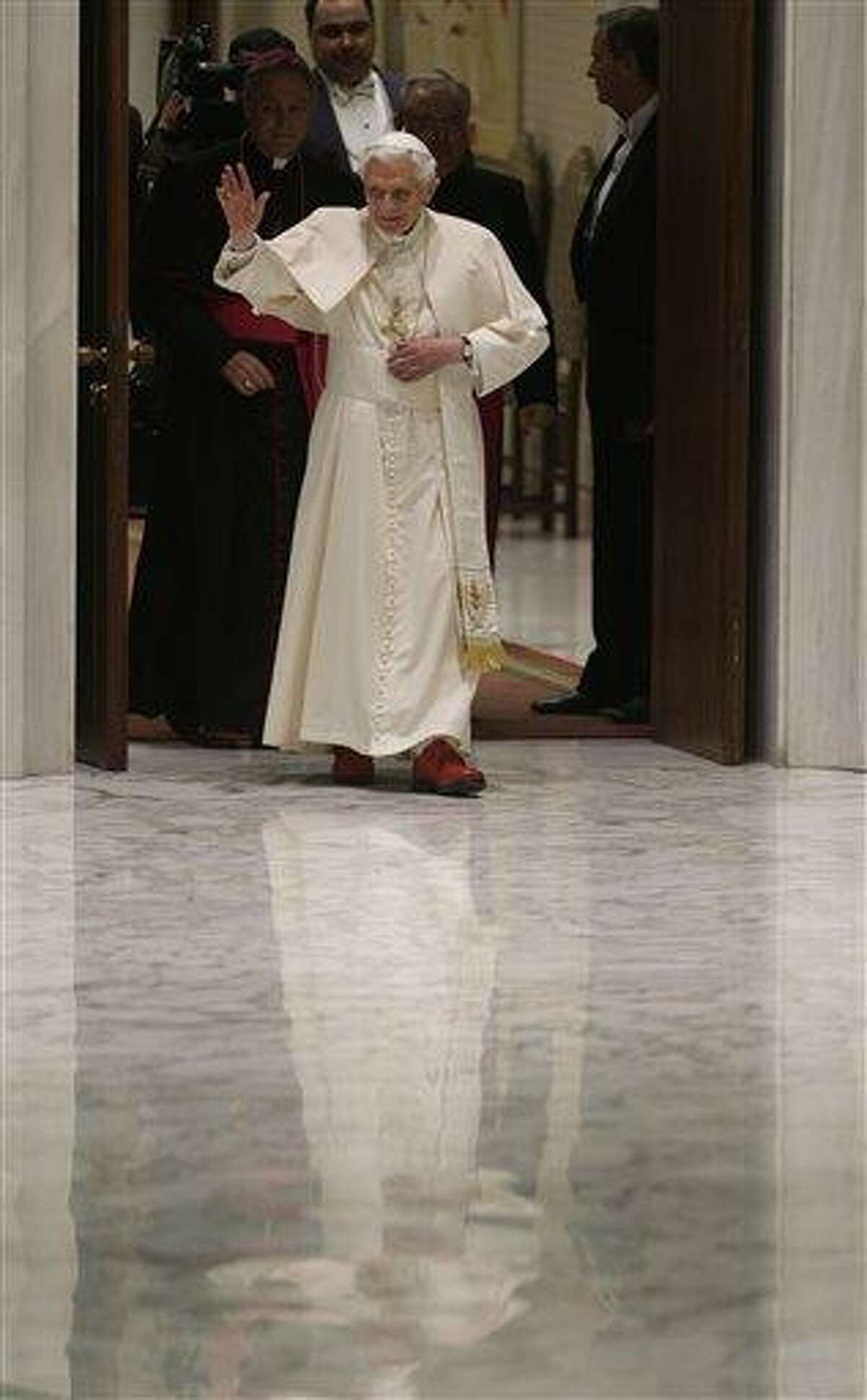 Pope Benedict XVI arrives for his weekly general audience at the Paul VI Hall at the Vatican, Wednesday Feb. 13, 2013. Thousands of people flooded the Vatican's main audience hall Wednesday for Pope Benedict XVI's first public appearance since his bombshell resignation announcement, taking advantage of his second-to-last public audience before retiring at the end of the month. AP Photo/Alessandra Tarantino
