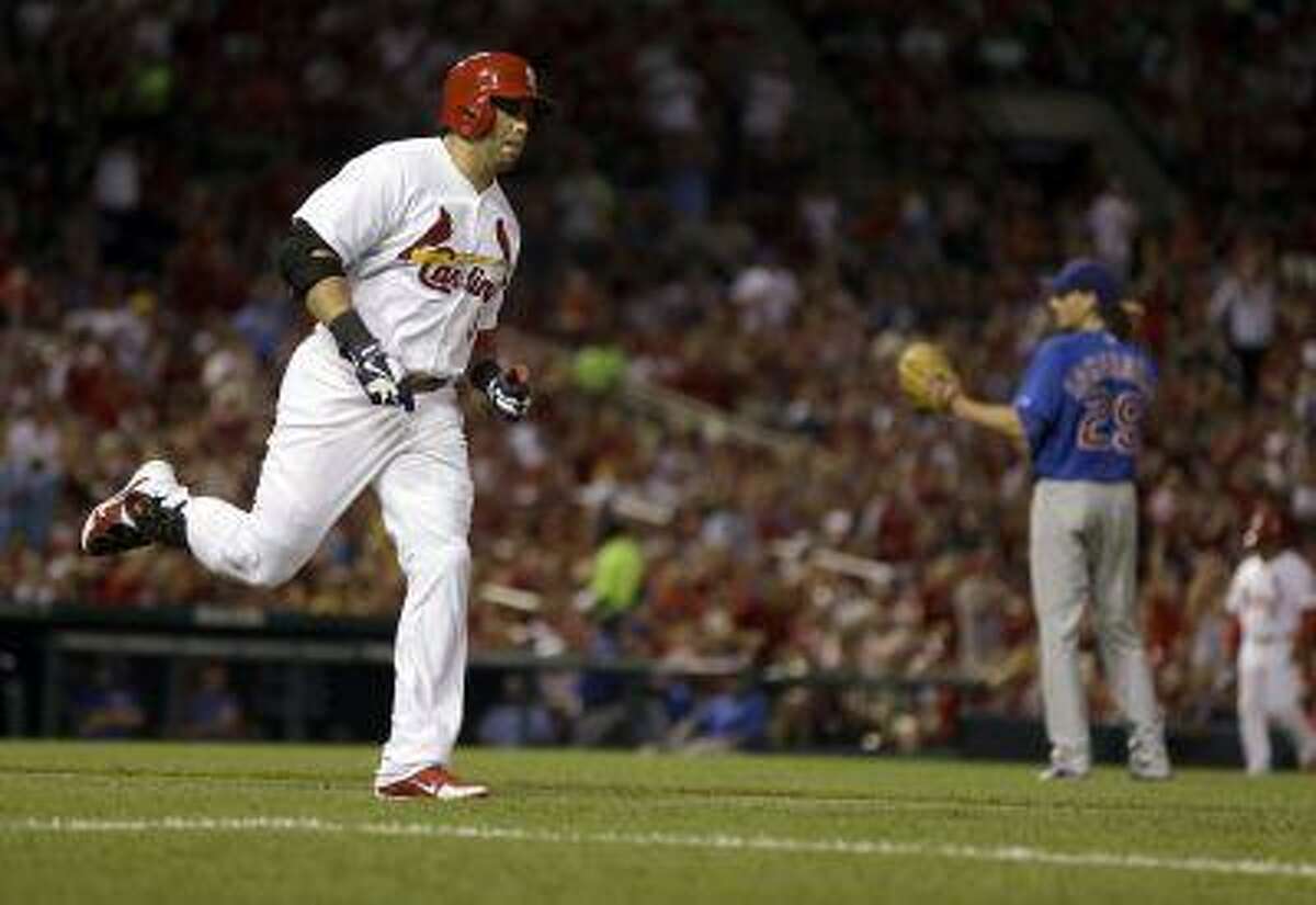 St. Louis Cardinals' Carlos Beltran, left, rounds the bases after hitting a solo home run off Chicago Cubs starting pitcher Jeff Samardzija, right, during the sixth inning of a baseball game on Tuesday, June 18, 2013, in St. Louis.