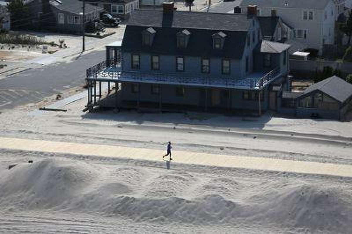 A resident jogs along a new stretch of boardwalk and restored beach more than six months after Superstorm Sandy in May 2013 in New Jersey. (John Moore/Getty Images)