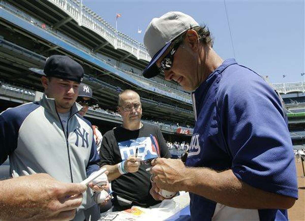 Los Angeles Dodgers manager Don Mattingly signs autographs for fans at Yankee Stadium before a baseball game against the New York Yankees Wednesday, June 19, 2013, in New York. (AP Photo/Kathy Willens)